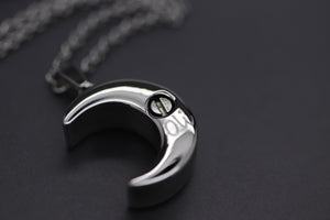 a black and white photo of a crescent pendant