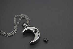 a necklace with a crescent and a skull on it