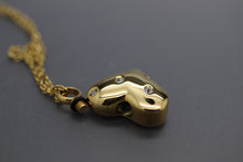 a gold necklace with an elephant head pendant