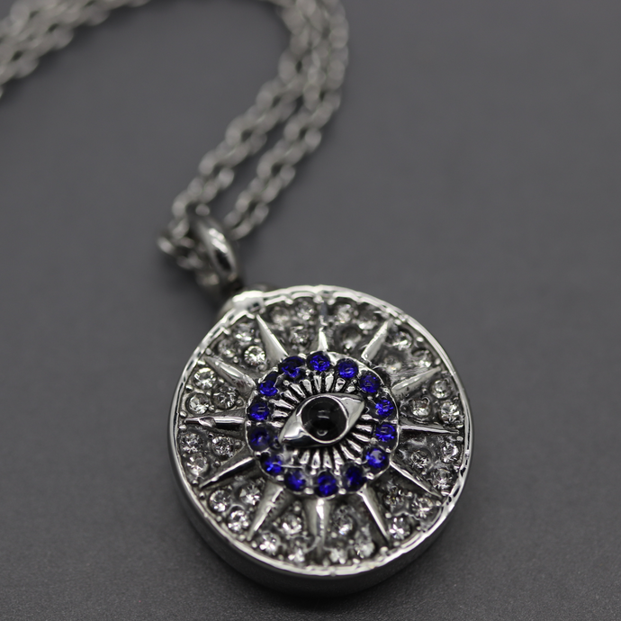 a silver necklace with a blue and white evil eye on it