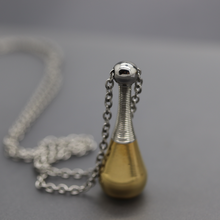 a small silver and gold necklace with a chain