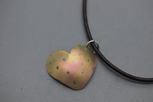a heart shaped pendant on a leather cord