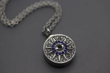a silver locke with a blue eye on a chain