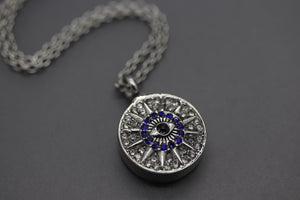 a silver locke with a blue eye on a chain
