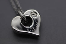 a heart shaped pendant with the word love written on it