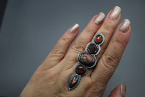 a woman's hand holding a ring with three stones