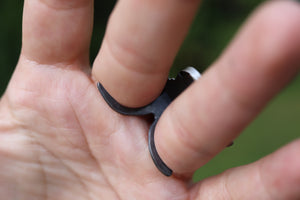 a person holding a black ring in their hand
