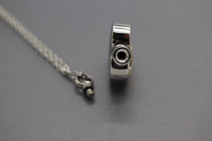 a silver necklace with a camera attached to it