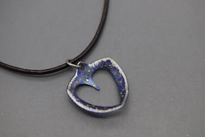 a silver and blue heart shaped pendant on a black cord