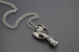 a necklace with a silver object on a chain