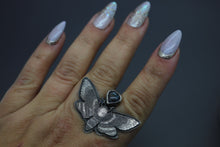 a woman's hand with a ring with a butterfly on it