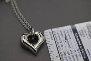 a close up of a heart shaped pendant on a chain