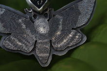a close up of a metal object with a butterfly on it