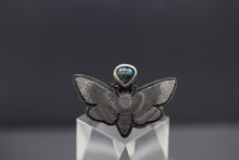 a silver ring with a butterfly design on it