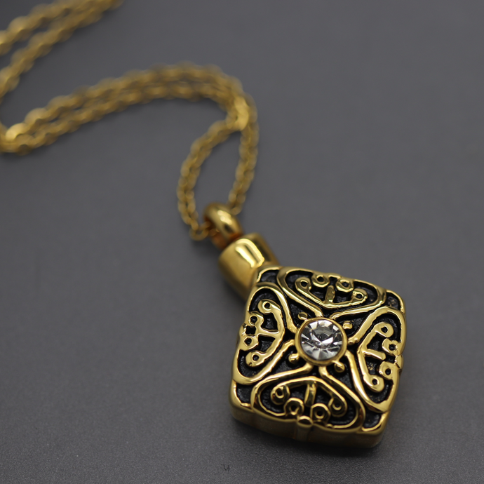 a gold pendant with a diamond on a chain
