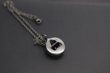 a silver necklace with a black cat on it