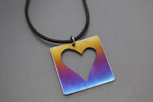 a square pendant with a heart cut out of it