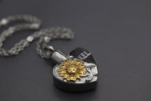 a silver and gold necklace with a flower on it